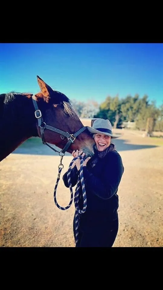 Tressa Boulden with her bay mare Allura being nuzzled