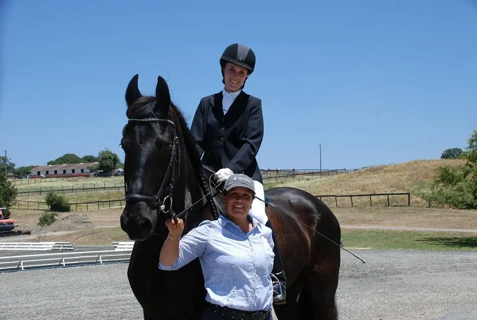 Paloma David mounted on a black horse with Tressa Boulden standing beside