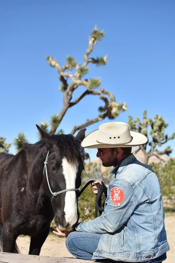 Jason sitting with his horse, Don Coyote